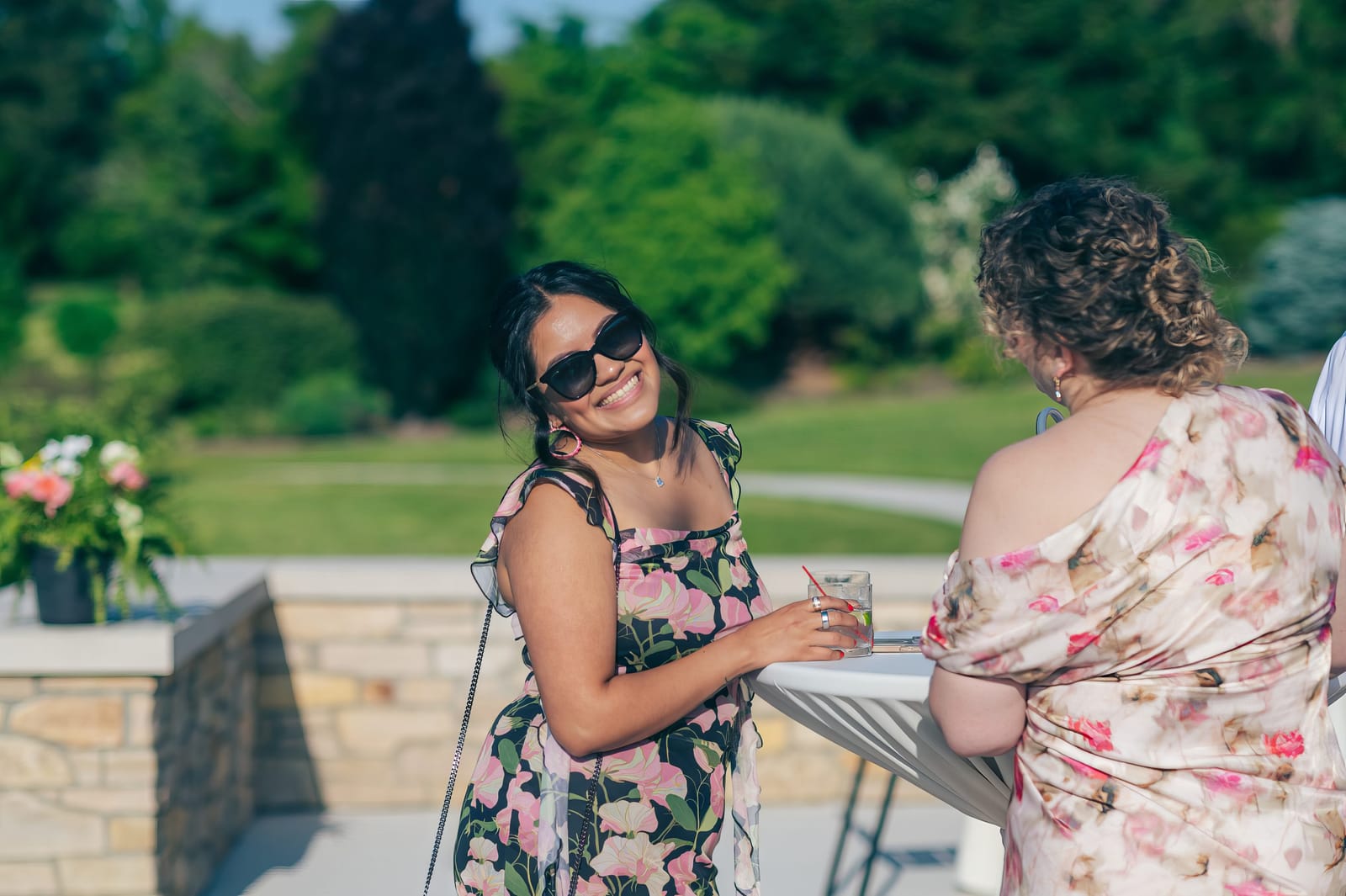 Two wedding guests laughing together outdoors